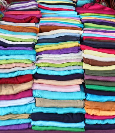 Colorful fashion scarves folded on market stallの写真素材