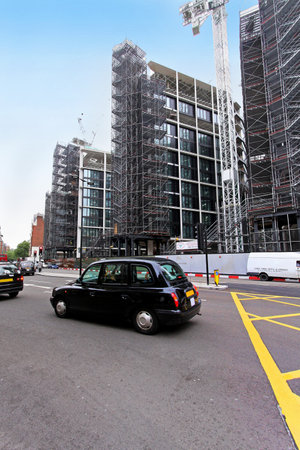 London, United Kingdom - May 27, 2009; Famous black cab on London street with Hyde Park One complex under construction in backgroundのeditorial素材