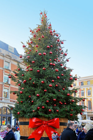 London, United Kingdom - November 19, 2011; Large Christmas tree outside on Covent Garden square in London during holidays with local people enjoying festive periodのeditorial素材
