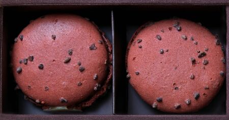 Couple of chocolate macaroons in cardboard boxの写真素材