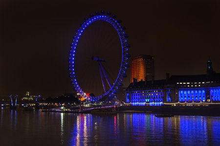 Famous London landmark London Eye Wheel during night over Thames river and blue lights in London, United Kingdom - November 17, 2013のeditorial素材