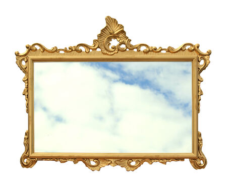 Old golden mirror frame with reflection of the skyの写真素材