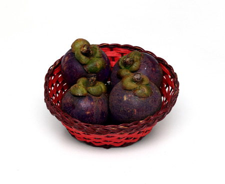 Fresh exotic fruit mangosteen in rattan red basketの写真素材