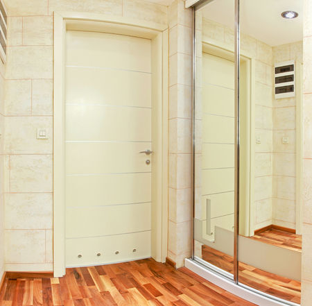 Closed door in modern interior corridor with mirror wallの写真素材