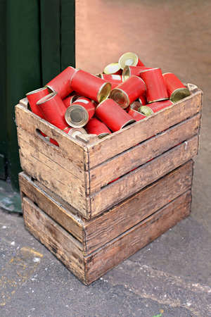 Red cans food inside wooden crate on marketの写真素材