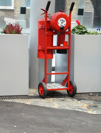 Mobile red fire extinguisher trolley with wheels and handlesの写真素材