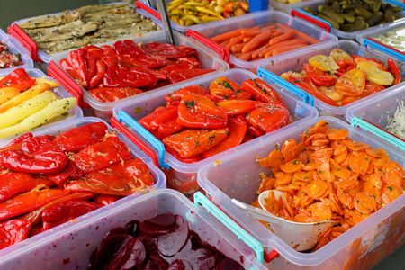 Pickled vegetables in plastic containers sold on green market stallの写真素材