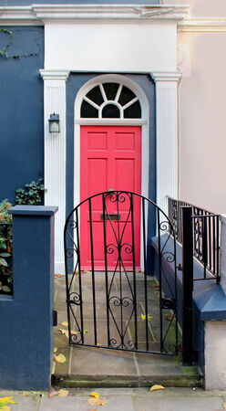 Residential entrance pathway with metal gate and pink doorの写真素材