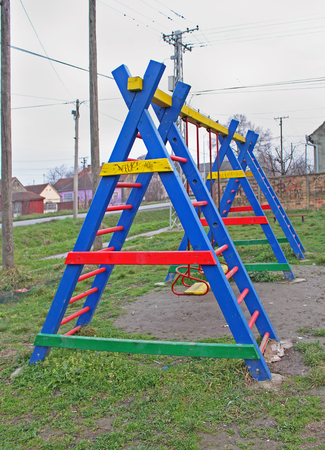 Colorful child playground with swing on rural field