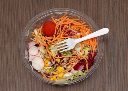 Fresh vegetables salad in takeaway plastic container with fork on topの写真素材