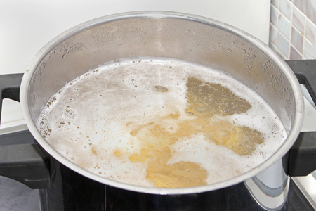 Pasta cooking in boiling water in silver containerの写真素材