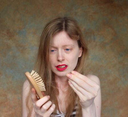 Young blonde women upset about losing her hairの写真素材