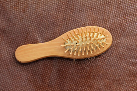 Small wooden hairbrush with blonde hair fallen off while brushingの写真素材