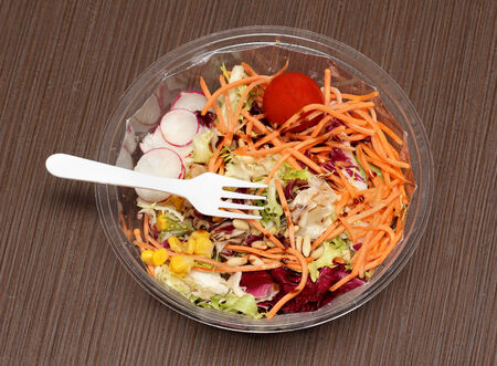 Fresh vegetables salad with plastic fork on topの写真素材