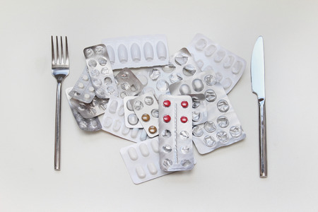 Pile of medicine pills with silverware cutleryの写真素材