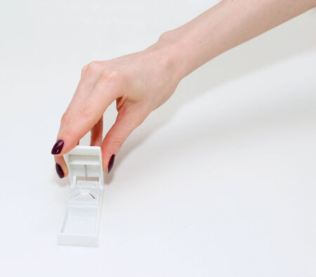 Female hand cutting a tablet in pill cutterの写真素材