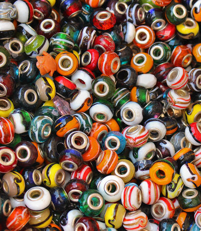 Pile of colorful beads with holes in the middle for making jewelryの写真素材