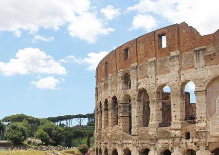 Detail of famous Italian landmark Roman Colosseum with trees in backの写真素材
