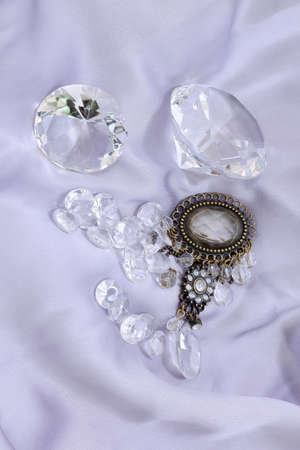 Luxury sparkling clear diamonds on silk sheetの写真素材