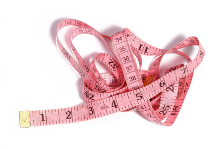 Pink tape measure rolled on white backgroundの写真素材