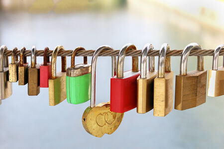 Padlocks on bridge chained to metal ropeの写真素材