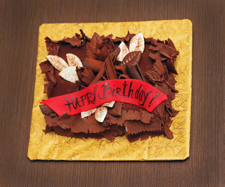 Chocolate cake with happy birthday sign on red bannerの写真素材