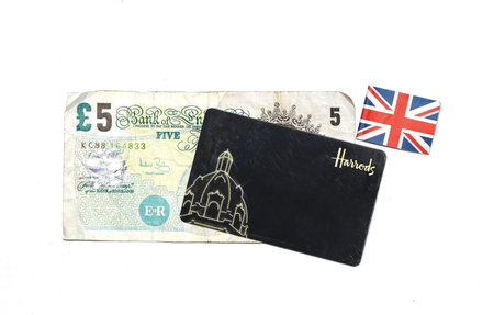 London, United Kingdom - July 28, 2014: Harrods department store loyalty card with five pounds bill...