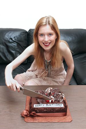 Young girl cutting her chocolate birthday cakeの写真素材