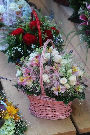 White roses bouquet inside pink wicker basketの写真素材