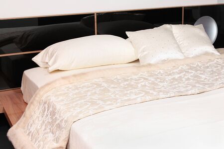 Modern bed detail with white bedding decorの写真素材