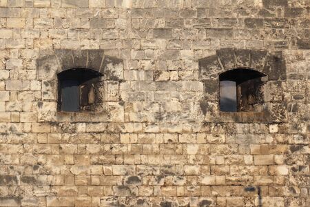 Two windows on old stone fortress exteriorの写真素材