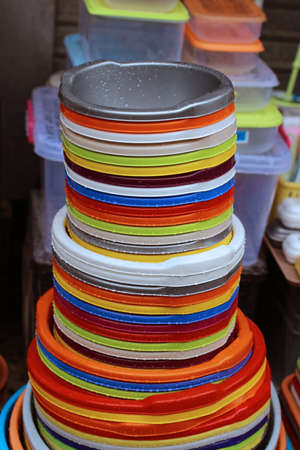 Big stack of colorful household plastic bowlsの写真素材