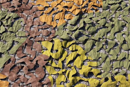 Military camouflage net pattern with green and brown materialの写真素材