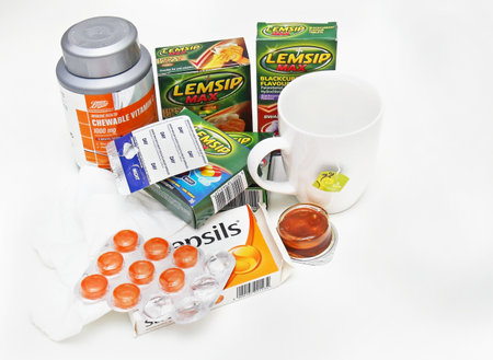 LONDON, UNITED KINGDOM - January 19, 2016: Set of over the counter remedies that help with overcoming flu symptoms paracetamol, tea, pastiles and vitamin Cのeditorial素材