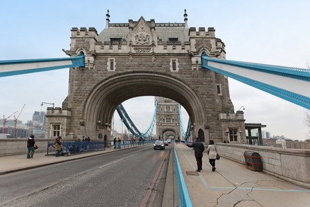 LONDON, UNITED KINGDOM - JANUARY 25: Tower bridge landmark with car traffic and people walking across on the sides in London, United Kingdom - January 25, 2013; Famous London landmark Tower Bridge with cars and people crossing on foot.のeditorial素材