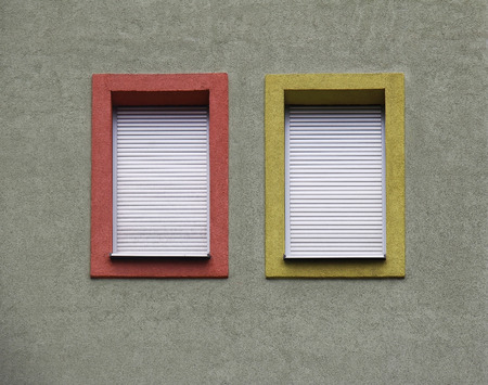 Stone facade exteriors with two closed windowsの写真素材