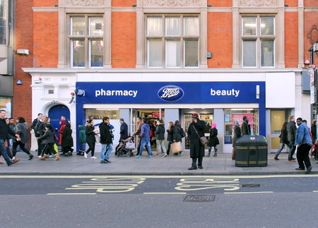 LONDON, UK - February 08: Famous beauty and pharmacy chain Boots on Oxford Street with pedestrians...