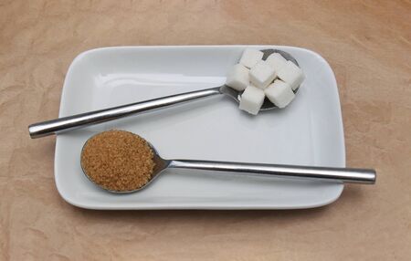 White sugar cubes and brown sugar on ceramic plateの写真素材