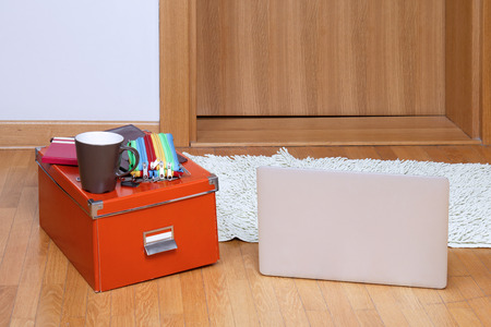 Laptop on floor with box of school stuffの写真素材