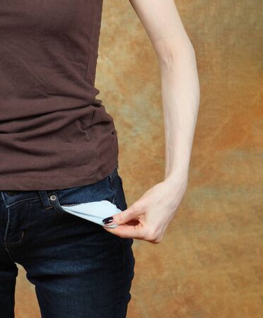 Poor broke woman showing her empty pocketの写真素材