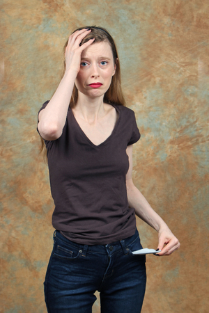 Young woman holding her head in desperation over povertyの写真素材