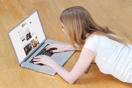 London, UK - February 06, 2015: Young girl looking for bargains online on Ebay shopping site. Ebay...