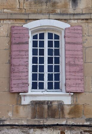 Old window exterior with open shades on decayed facadeの写真素材