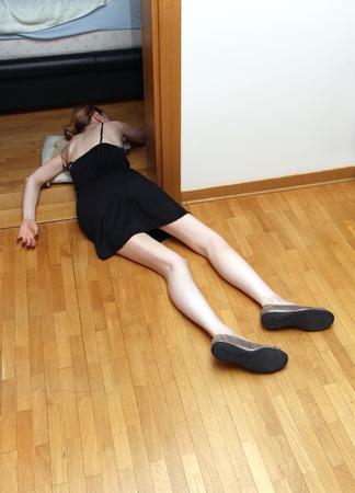 Young woman laying on the floor after drug overdoseの写真素材