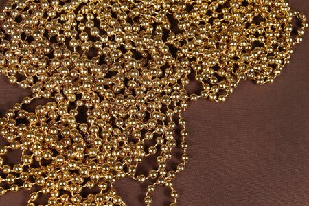 Gold pearls chain on brown backgroundの写真素材