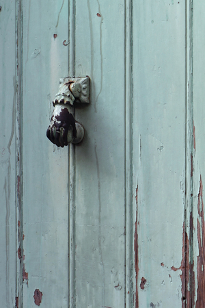 Old metal door knocker on wood door surfaceの写真素材