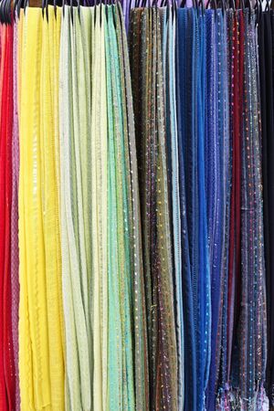 Soft colorful scarves hanging on rack in storeの写真素材