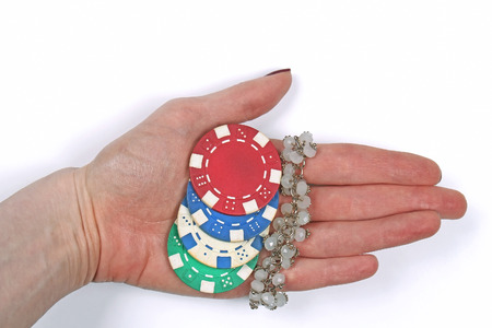 Female hand holding gambling chips and pearl braceletの写真素材