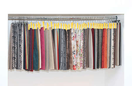 Furniture upholstery pattern samples on hangers on the wallの写真素材