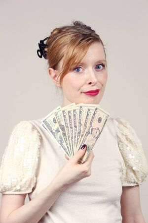 Young woman holding US dollars paper bank notesの写真素材